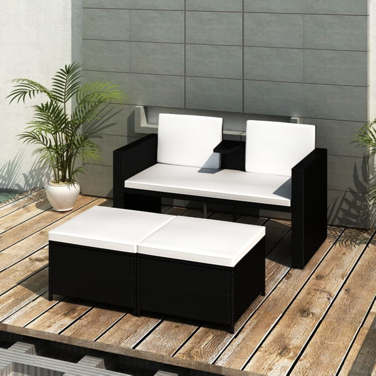 Schwarzes Outdoor-Möbelset aus Korbgeflecht mit weißen Kissen auf einem Holzdeck.