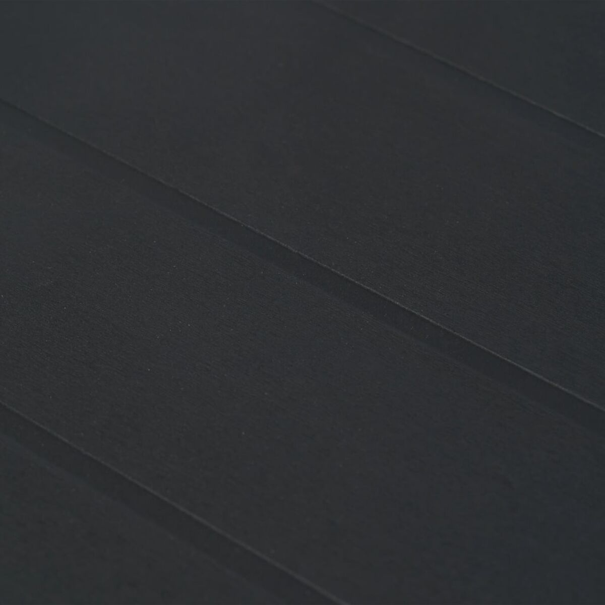 Nahaufnahme von schwarzen Holzlatten. Diagonale Linien, dunkle Töne.