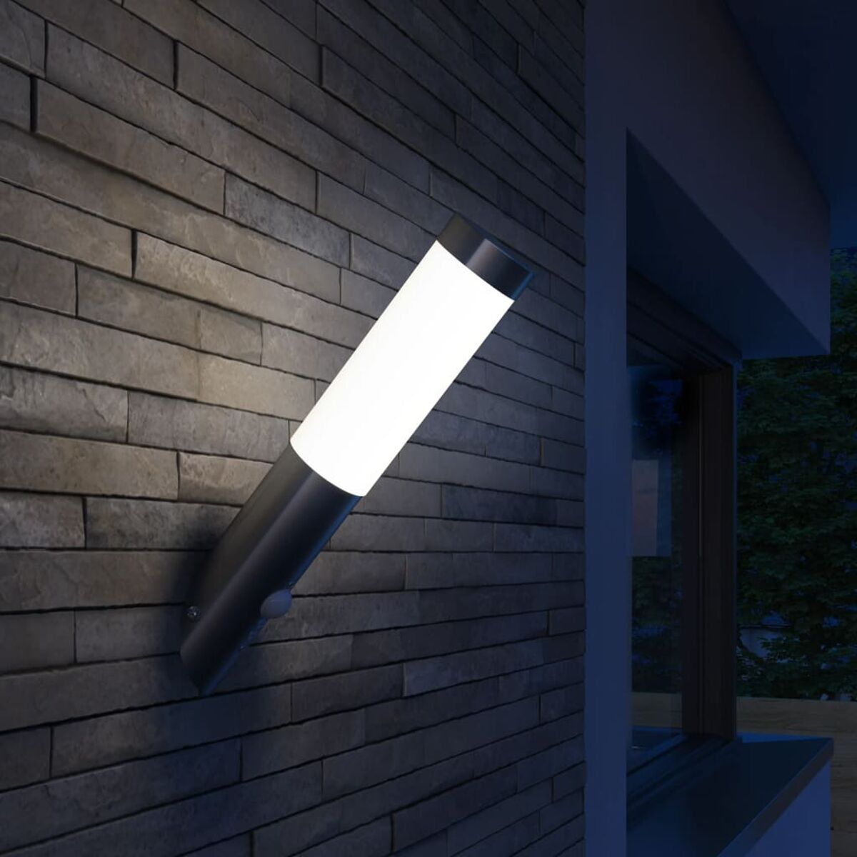 Moderne, silberne Außenwandleuchte, die bei Nacht hellweißes Licht gegen eine Ziegelmauer abstrahlt.