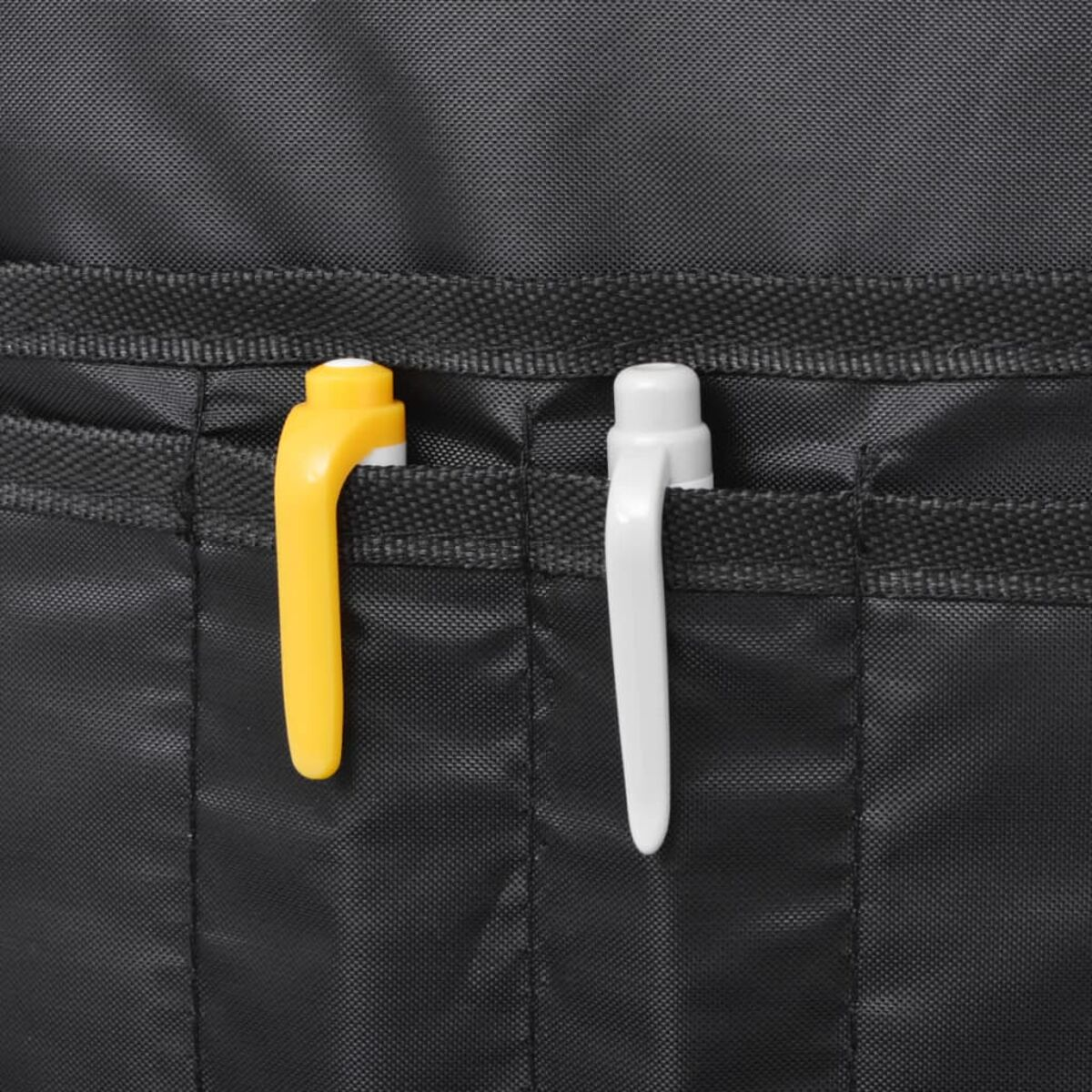 Nahaufnahme einer schwarzen Tasche mit Taschen. Zwei Stifte, gelb und weiß, befinden sich in den Taschen.