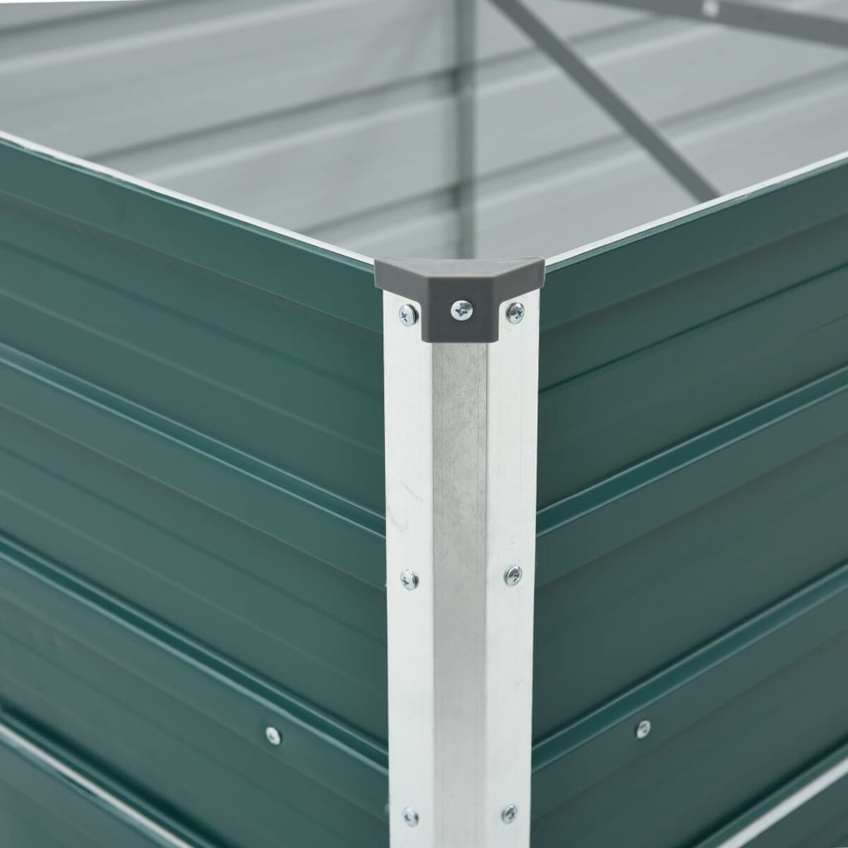 Ecke eines grünen Metall-Gartenbeetes. Die Ecke ist mit Silbermetall verstärkt.
