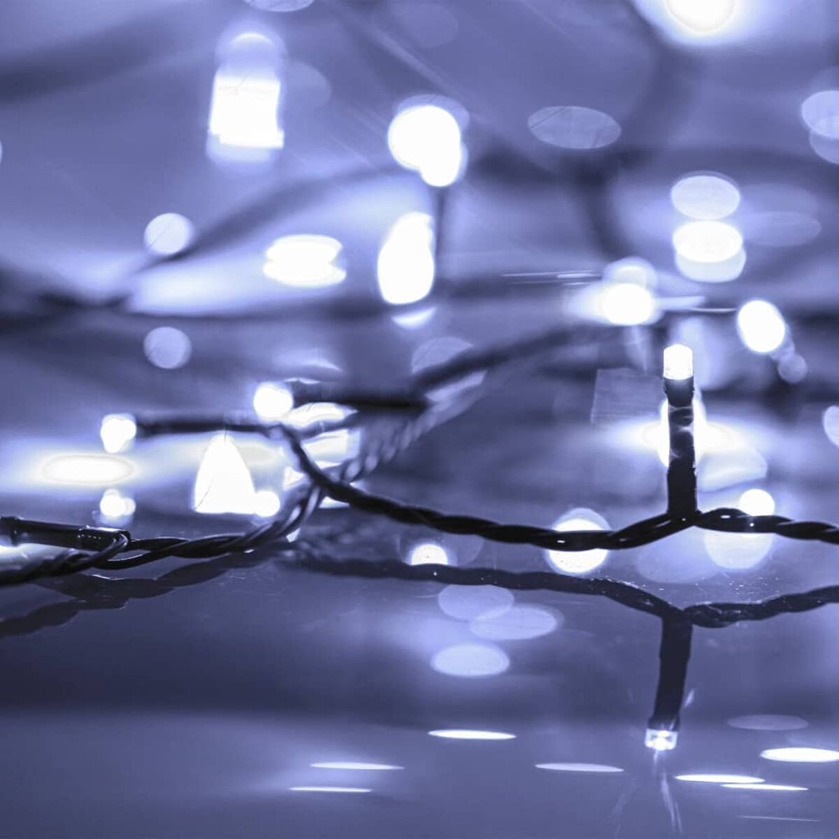 Verschwommene Lichterketten mit vielen hellen weißen Lichtern, Bokeh-Effekt, purpurner Ton.