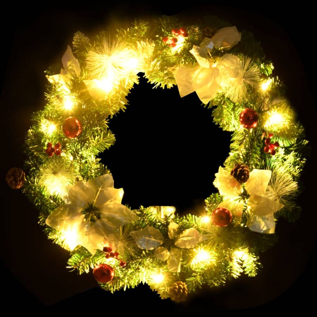 Ein Weihnachtskranz mit Lichtern, roten Ornamenten und weißen Blumen, schwarzer Hintergrund.