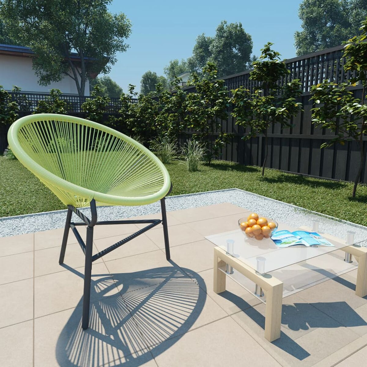 Grüner Drahtstuhl auf Terrasse. Tisch mit Orangen und Buch. Bäume und Rasen.