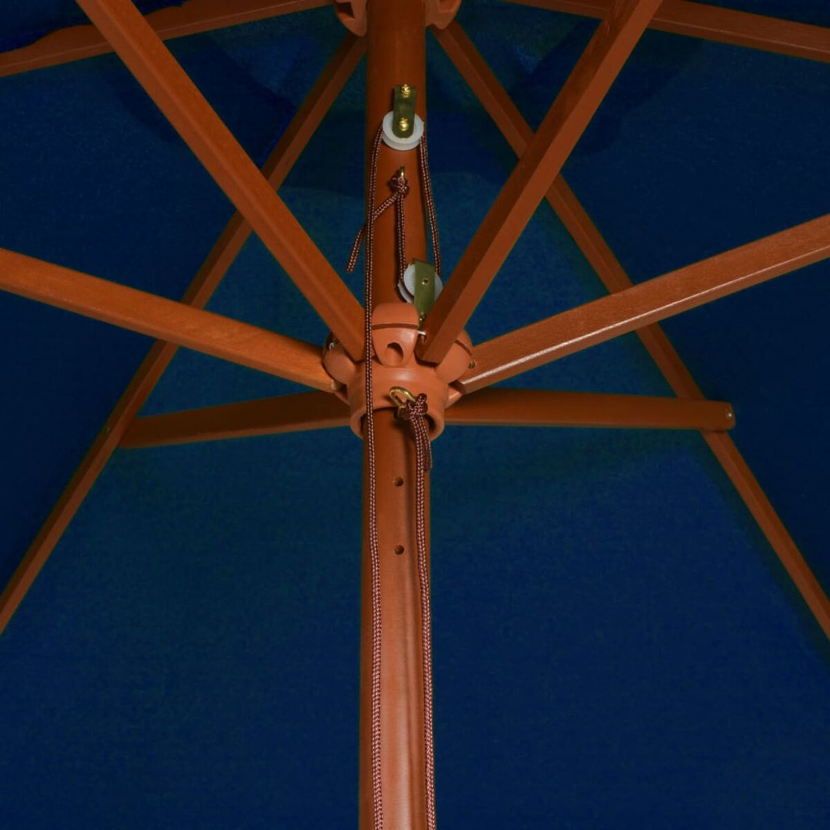 Nahaufnahme des Holzrahmens eines Schirms. Blauer Stoff und Seile sind sichtbar.