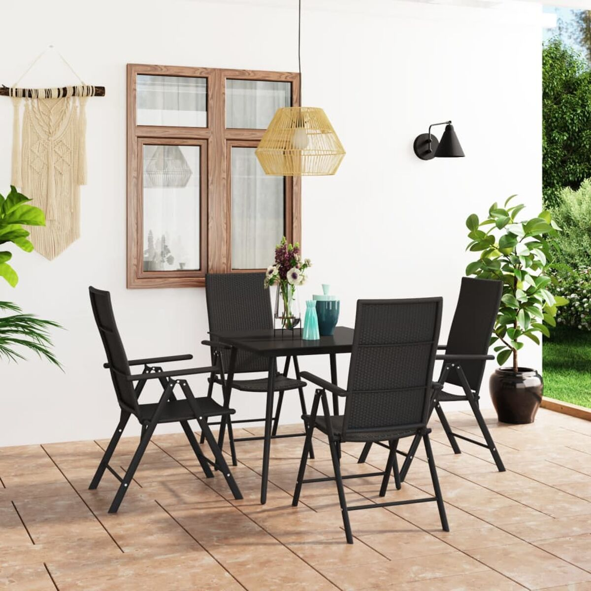 Szene im Freien mit Tisch, Stühlen, Pflanzen und einer Hängeleuchte. Schwarze Möbel, weiße Wand und brauner Holzboden.