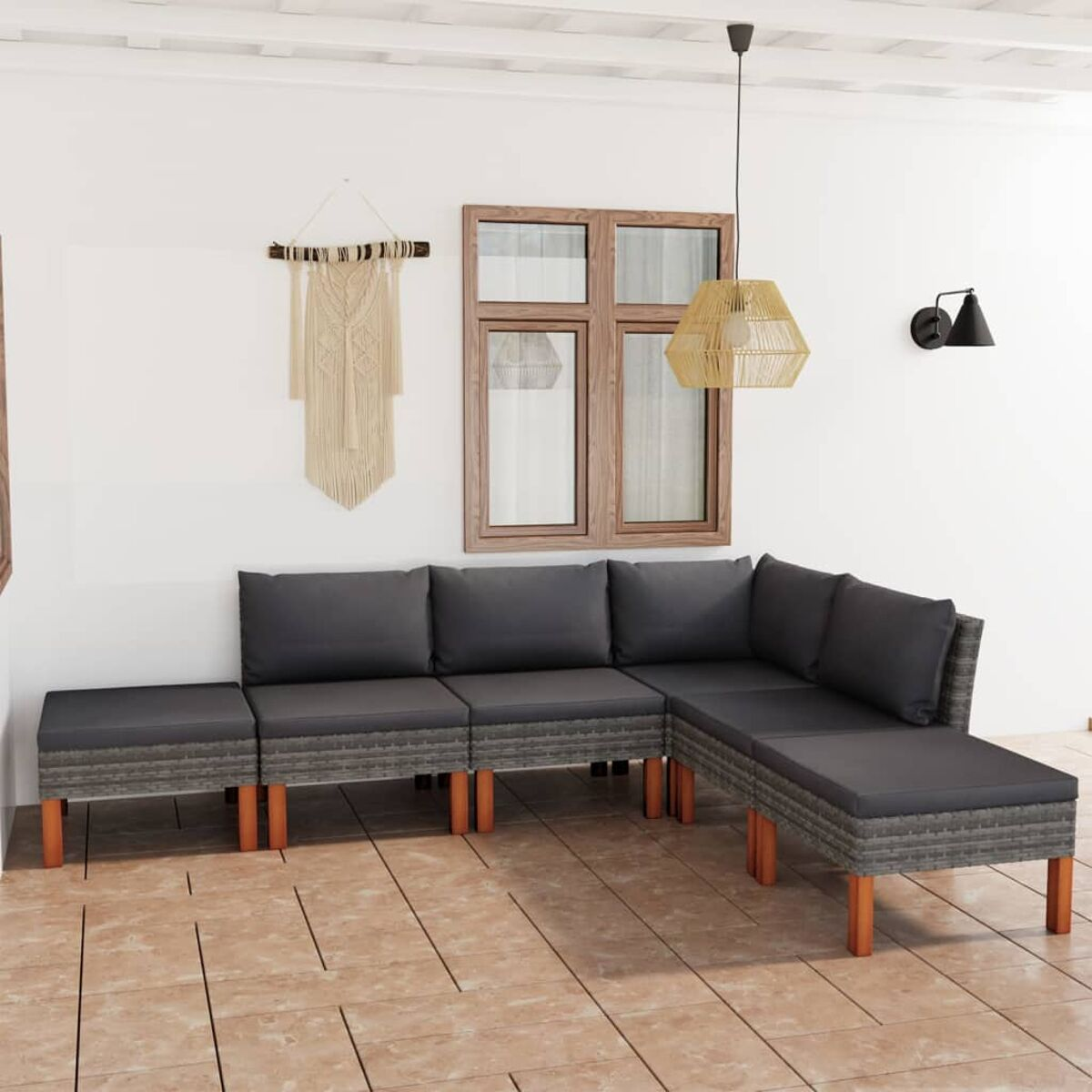 Ein Sitzbereich im Freien mit grauem Ecksofa, beiger Wand und Dekoration.