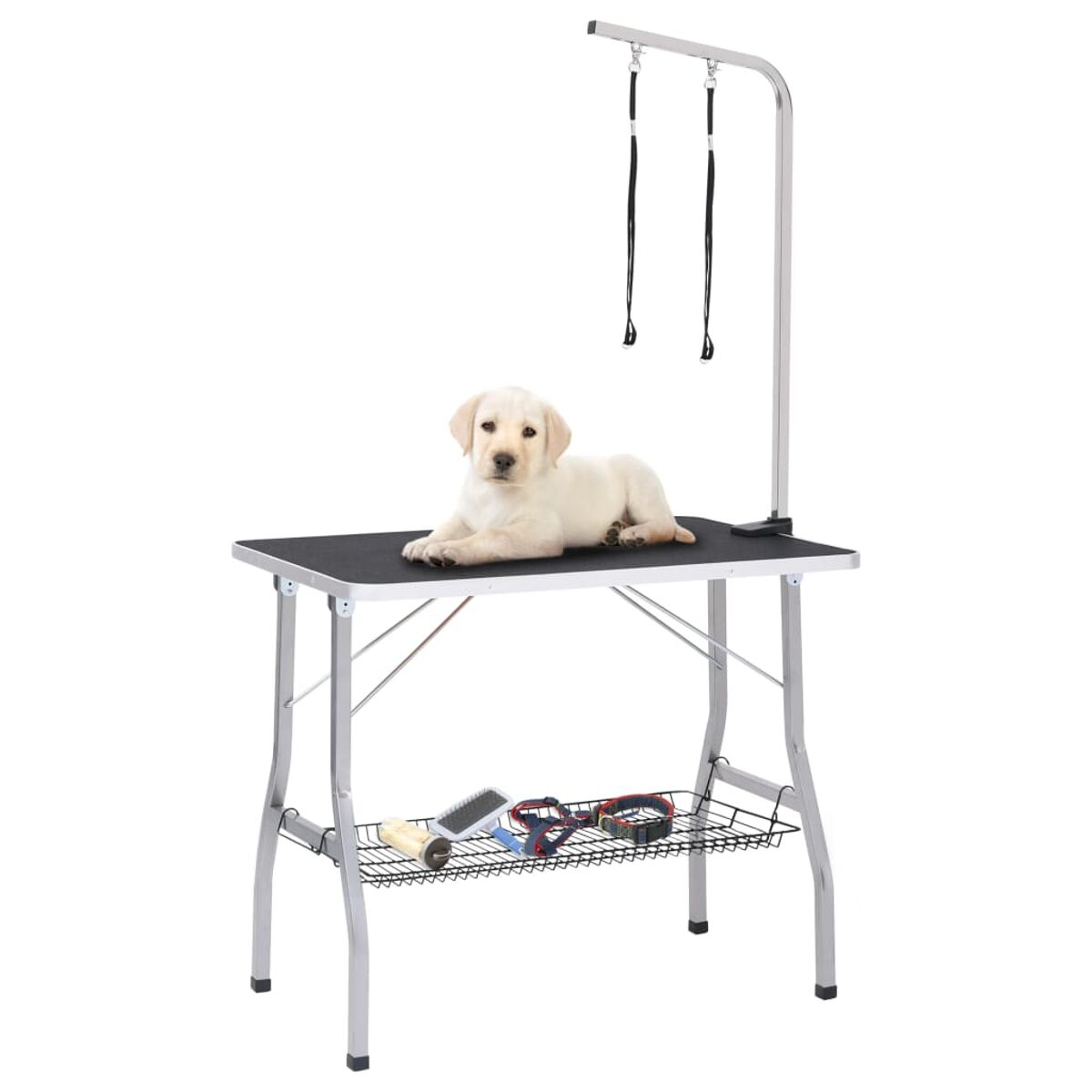 Ein Welpe liegt auf einem Pflegetisch. Unter dem Tisch befinden sich Pflegeutensilien. Der Tisch hat ein Metallgestell.