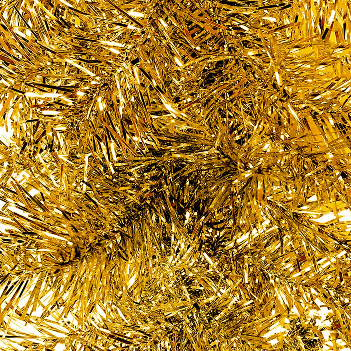Nahaufnahme von goldenem Lametta. Glänzend, reflektierend und dicht gepackt. Weißer Hintergrund.