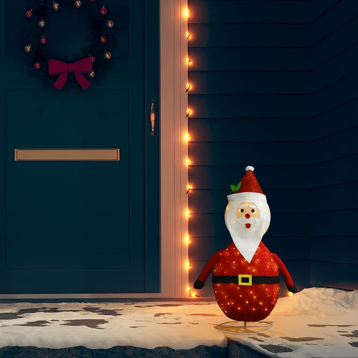 Weihnachtsmann-Dekoration mit Lichtern, neben einer Tür und Kranz.