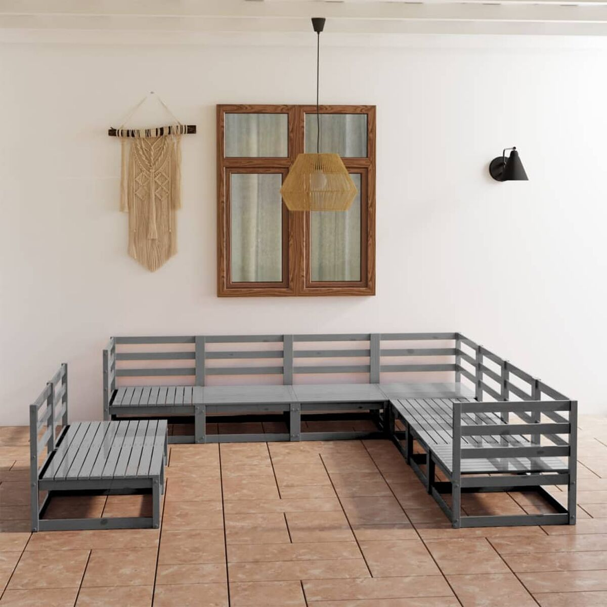 Sitzbereich im Freien. Holz-Ecksofas in Grau mit Makramee-Wandbehang und Pflanzen.