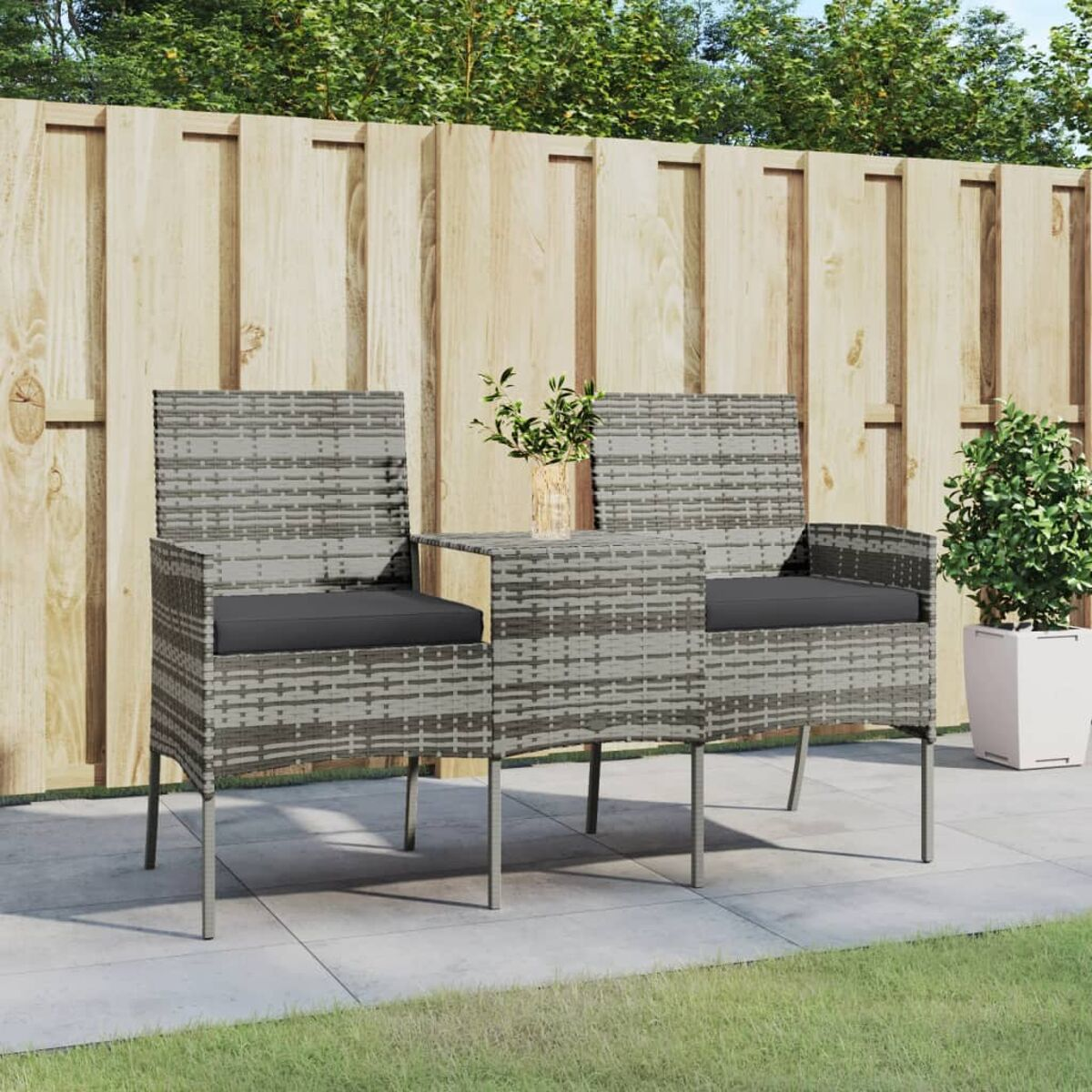 Outdoor-Terrassenset mit zwei Stühlen, kleinem Tisch und einer Pflanze. Graues gewebtes Material.