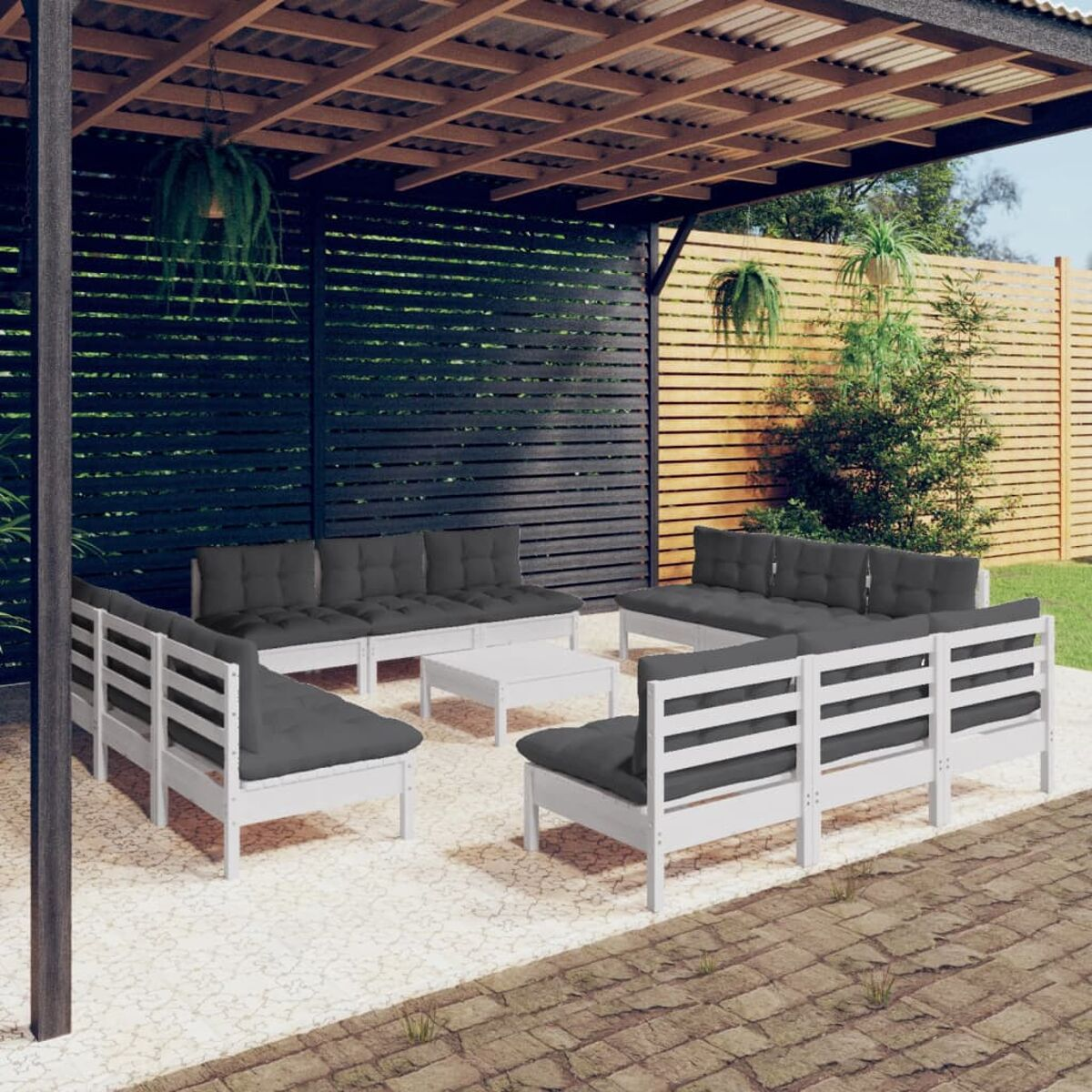 Sitzbereich im Freien mit Sofas mit weißem Rahmen, einem weißen Tisch und einer schwarzen Pergola. Steinboden.