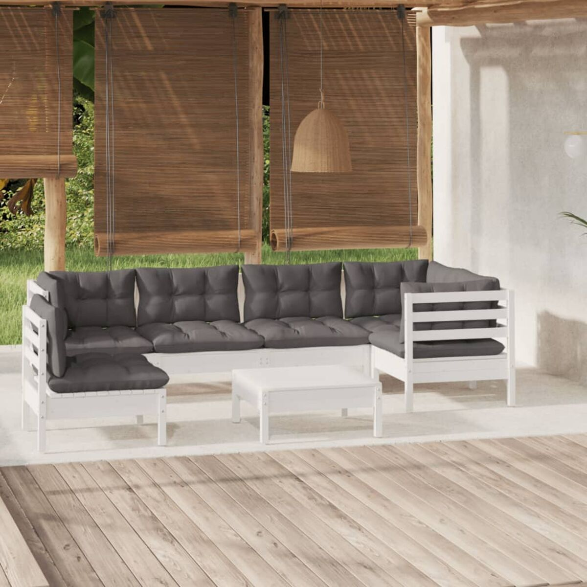 Weißes Outdoor-Sofaset mit grauen Kissen, Couchtisch und Holzterrasse. Pflanzen im Hintergrund.