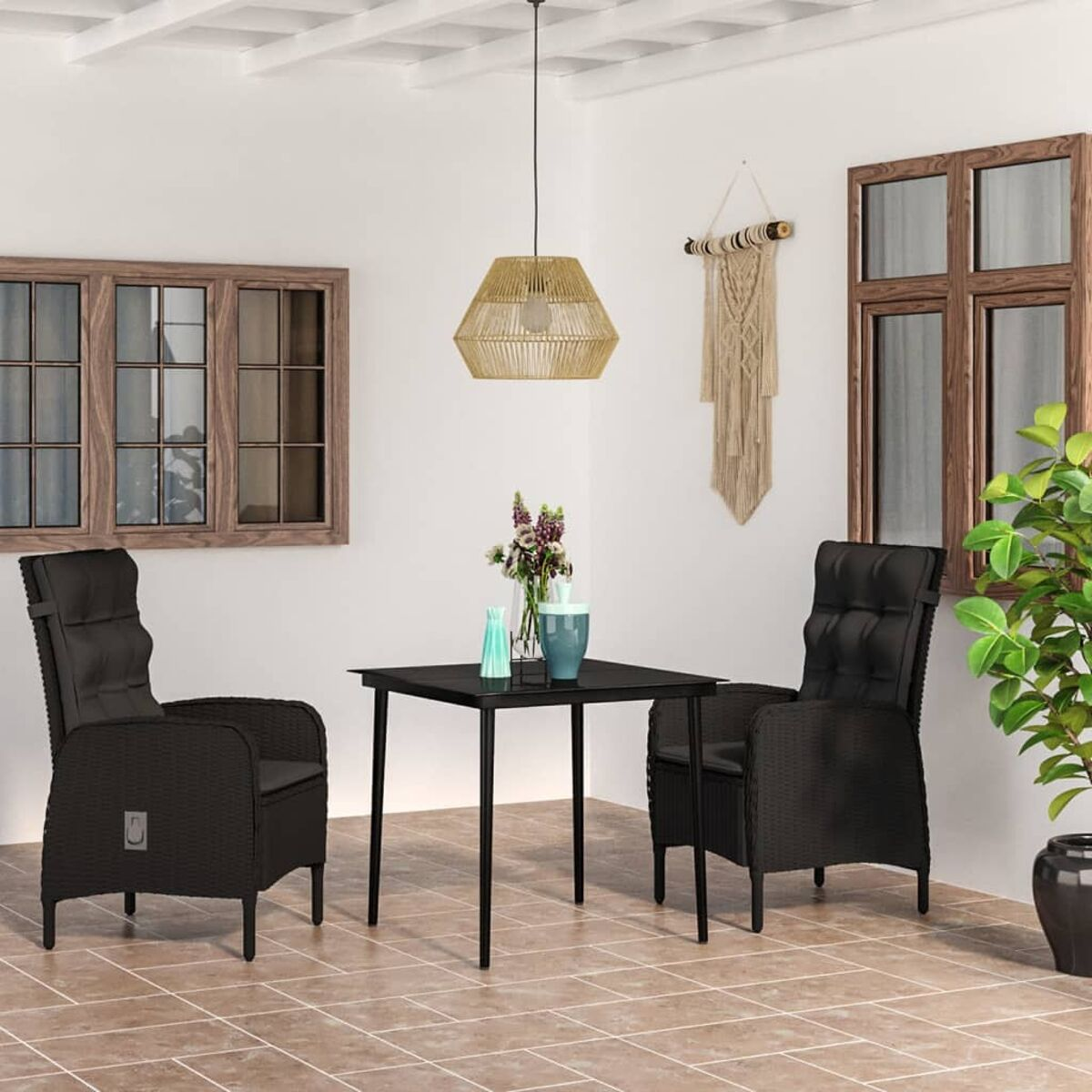 Schwarze Korbstühle und Tisch. Schwarze Kissen. Holzfensterrahmen. Beiger Fliesenboden.