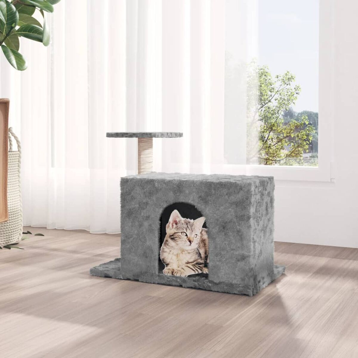 Eine Katze in einem grauen Katzenhaus. Das Haus befindet sich in einem Raum mit Fenster und kleiner Plattform.
