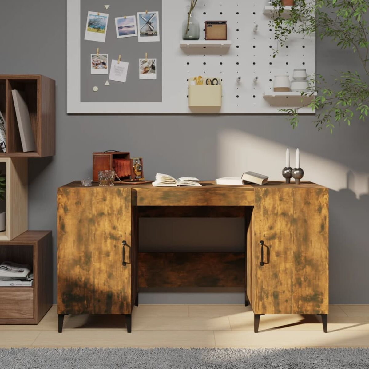 Ein Holzschreibtisch mit Schubladen, eine weiße Tafel mit Fotos und Deko.