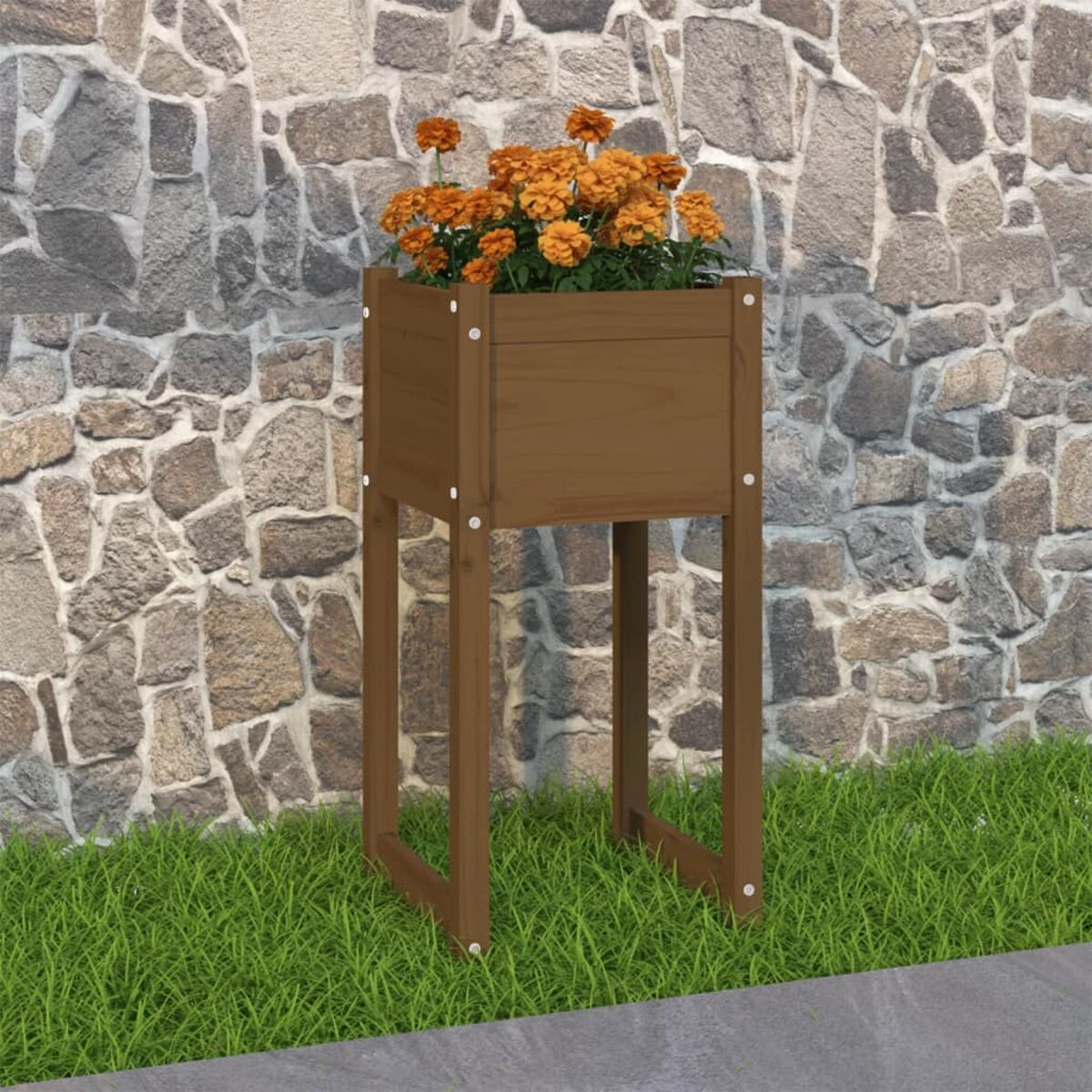 Ein Holzpflanzer mit orangen Blumen, auf Gras vor einer Steinmauer.