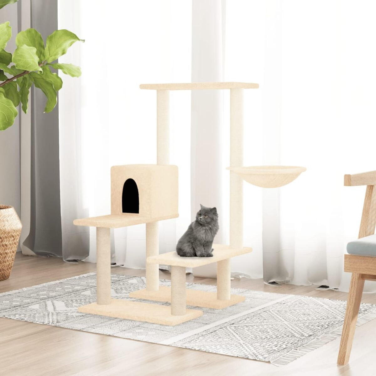 Ein Katzenbaum neben einem Fenster. Eine graue Katze sitzt auf einer Plattform.