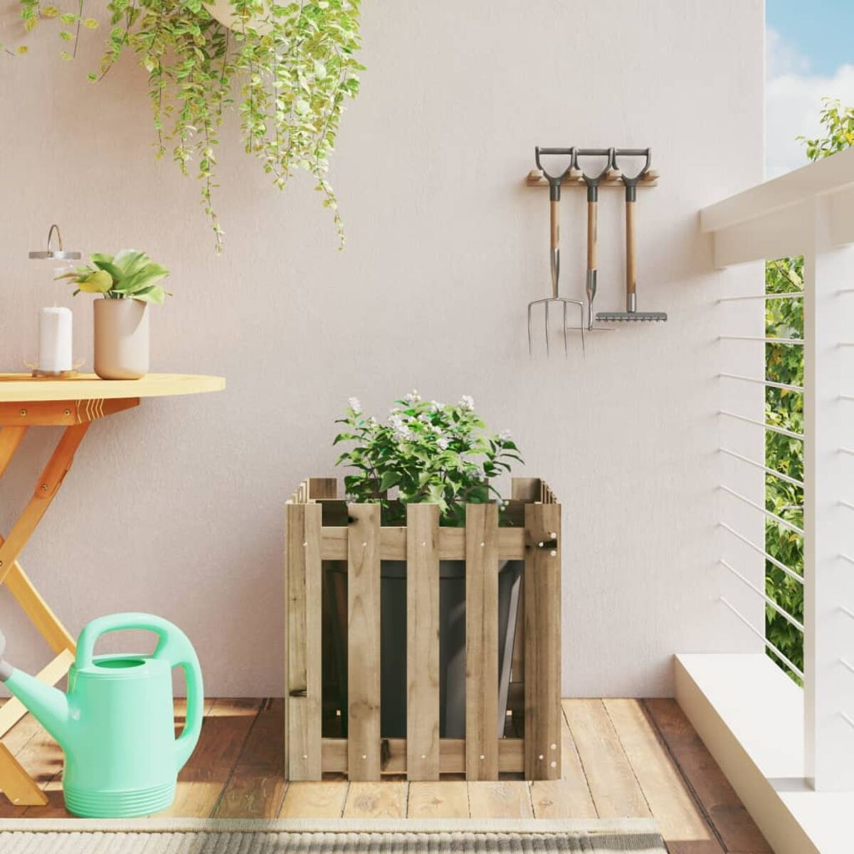 Holzpflanzkasten mit Pflanzen, Gießkanne und Gartengeräten auf einem Balkon.