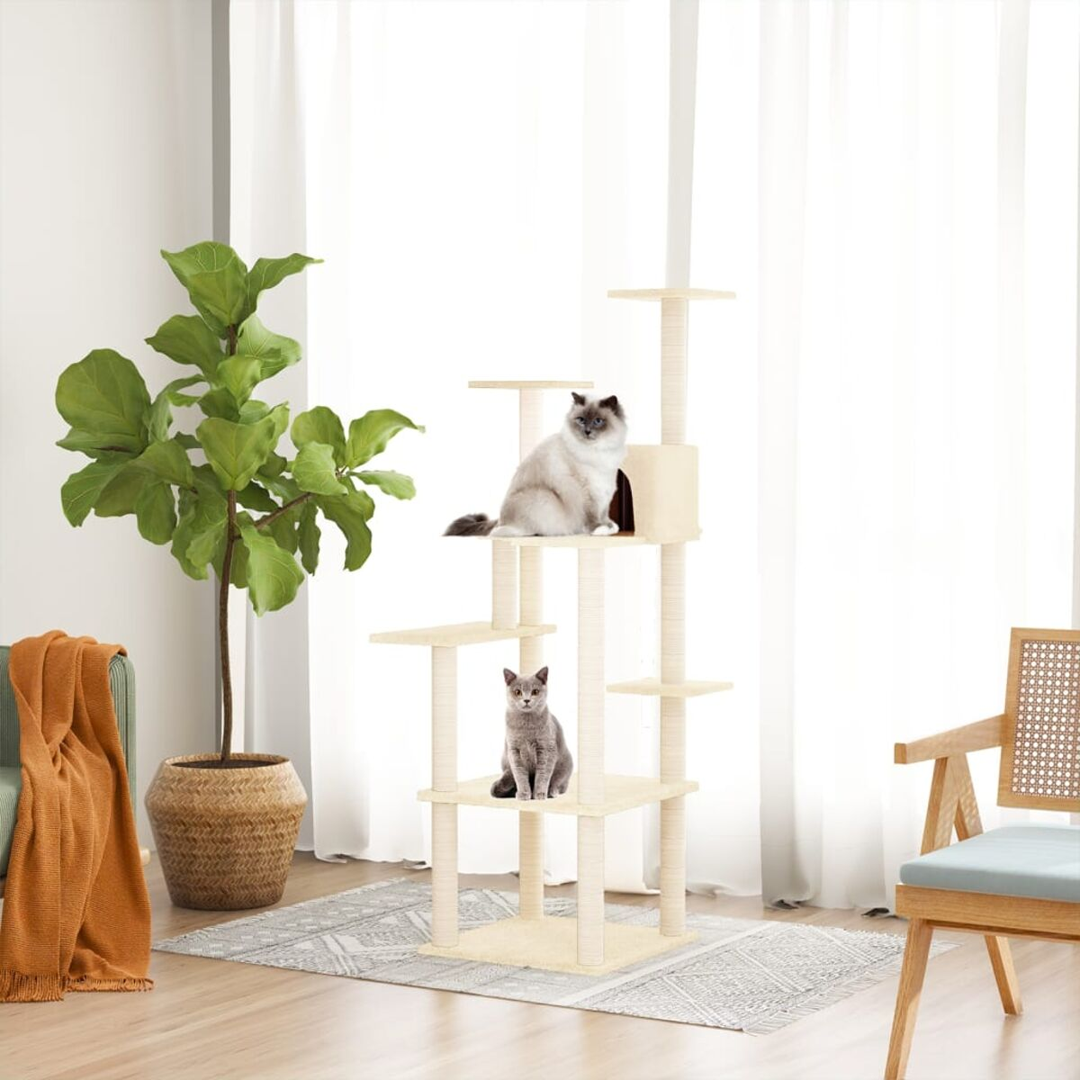 Kratzbaum mit zwei Katzen: eine graue, eine weiße. Pflanzen und Vorhänge im Hintergrund.