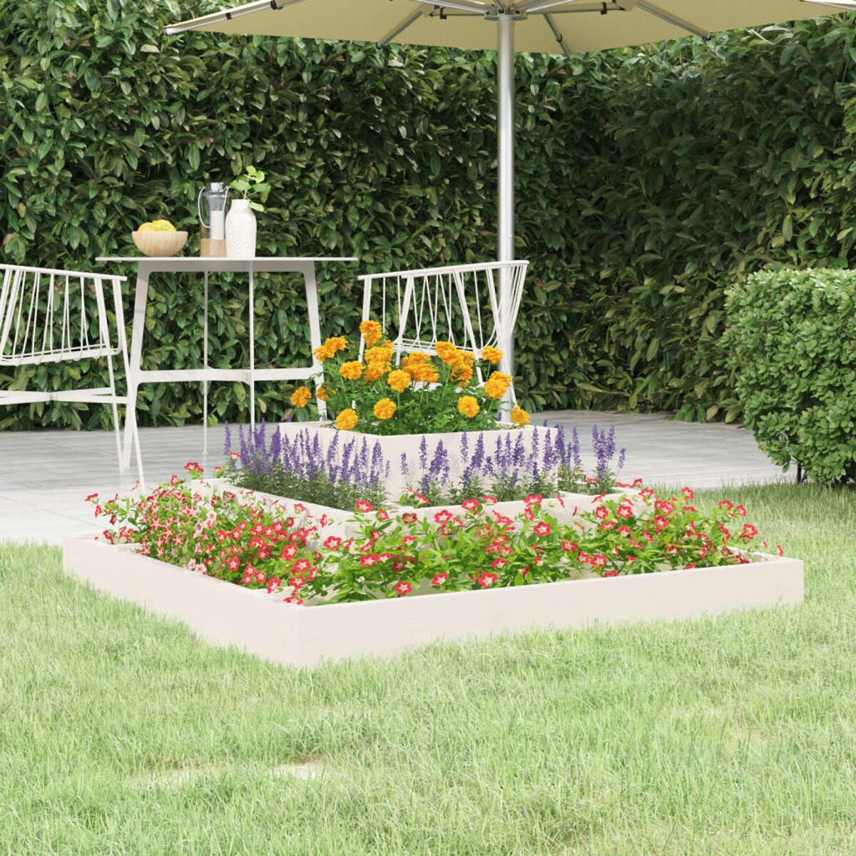 Blumen in gestuften Pflanzkästen auf Gras, mit Schirm, Tisch und Stühlen.