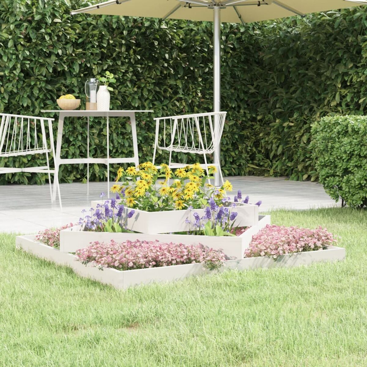 Gartenszene. Mehrstufige Blumenbeete mit bunten Blumen, weißem Tisch, Stühlen und einem beigen Sonnenschirm.