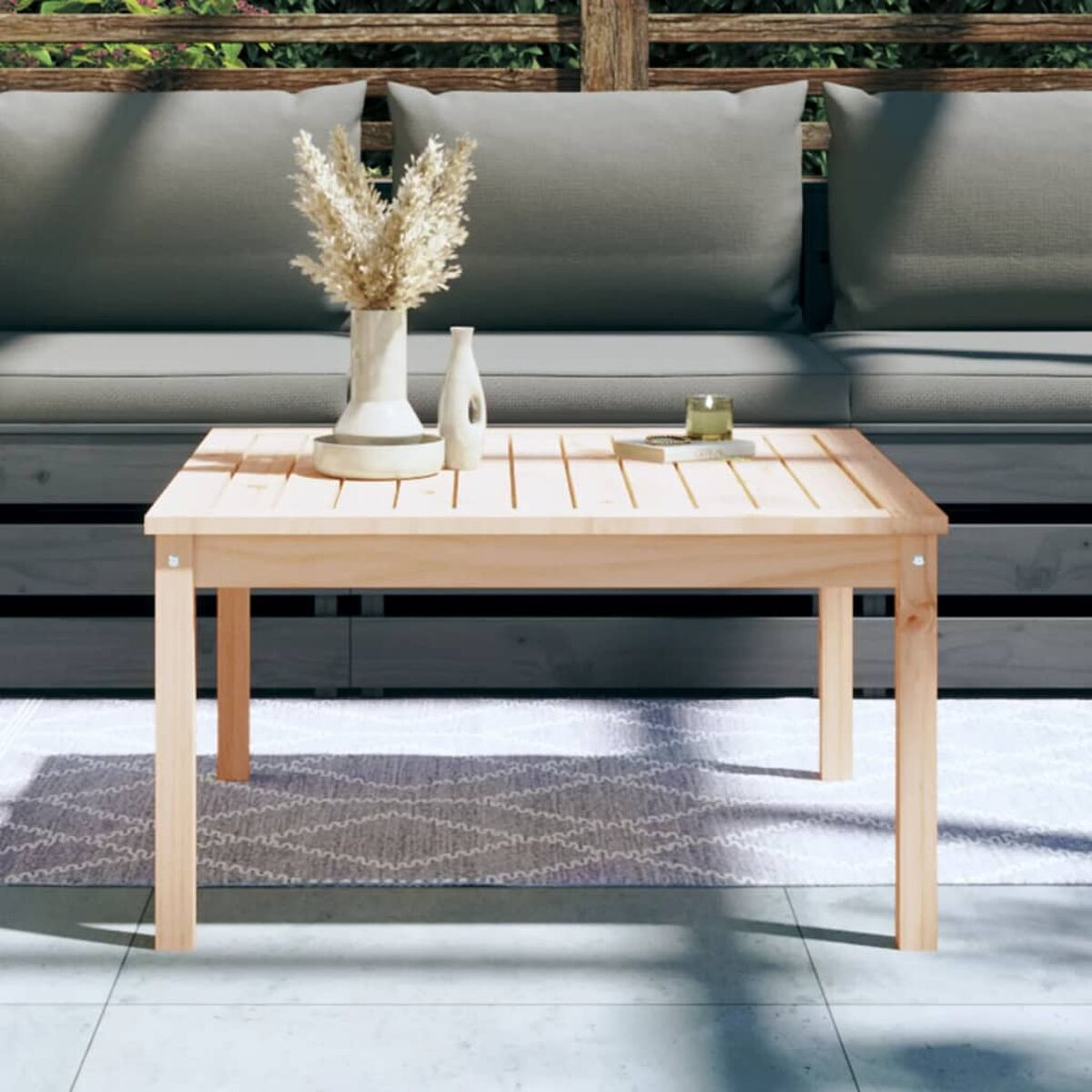 Couchtisch aus hellem Holz mit Vase, Blumen, Kerze und Tablett.