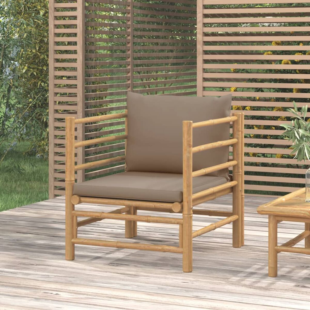 Bambusstuhl mit braunem Kissen, von der Seite gesehen. Holzterrasse und ein Tisch.
