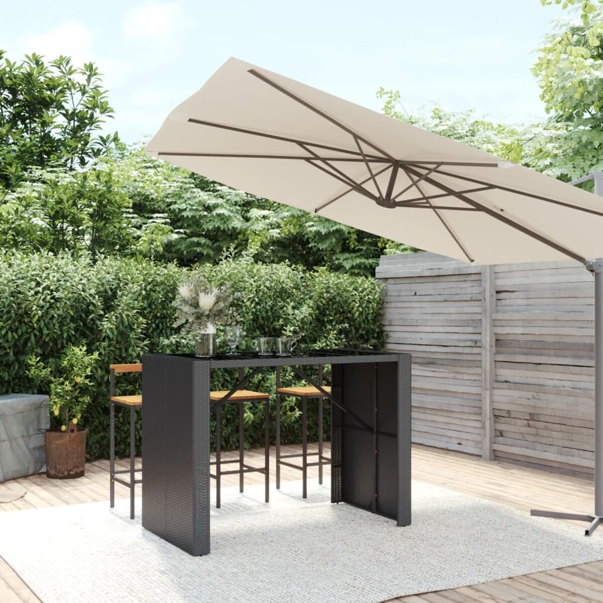 Outdoor-Bar mit schwarzem Tisch, Hockern und großem beigen Schirm. Auf einer Terrasse im Garten.