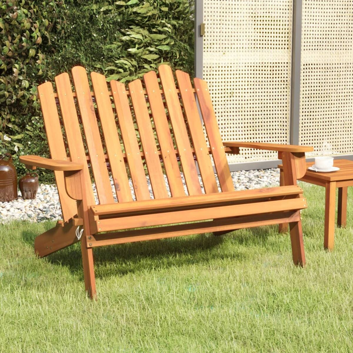 Gartenbank aus Holz mit Lattenlehne, auf grünem Gras, Beistelltisch und Pflanzen.