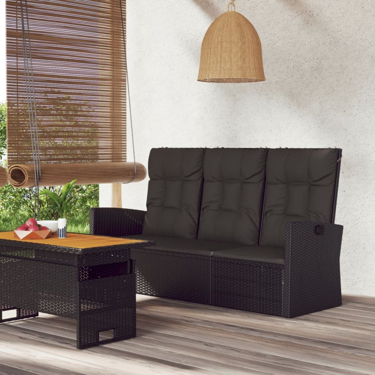 Ein schwarzes Korbmöbel-Sofa und ein Holztisch mit Hintergrund.