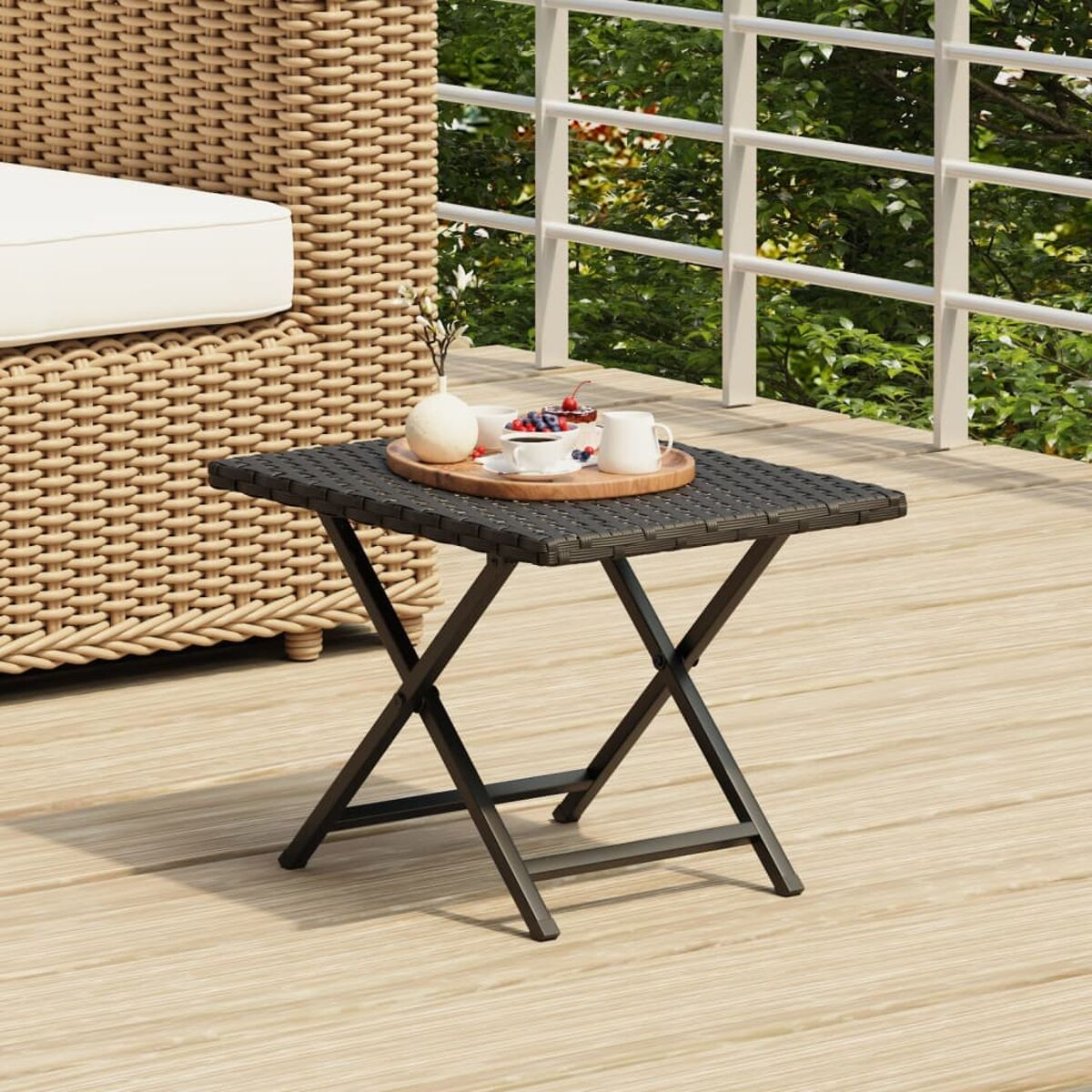 Kleiner, quadratischer, schwarzer Korbtisch. Holztablett mit Gegenständen, auf einem Deck.