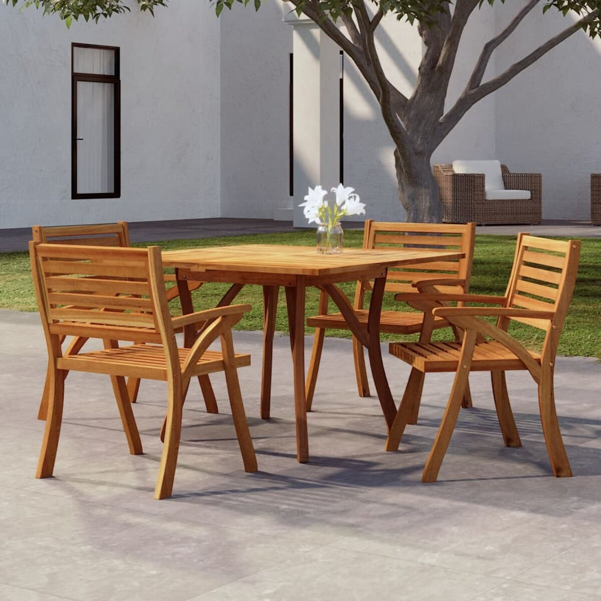 Ein Holztisch und Stühle im sonnigen Außenbereich, mit Blumen.
