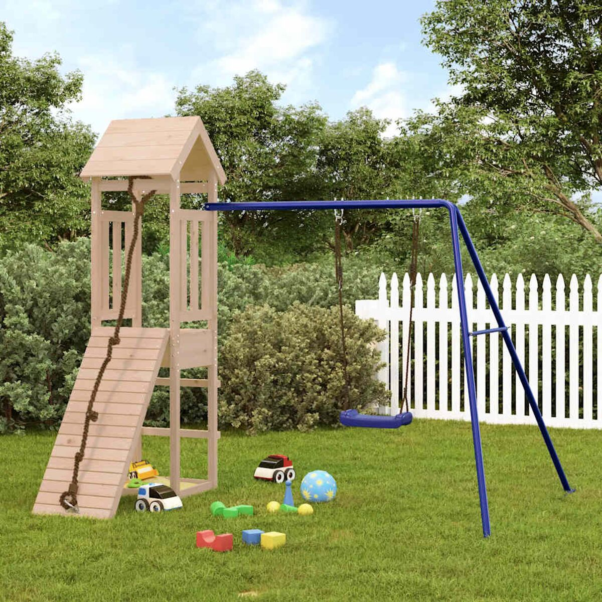 Spielplatz mit Rutsche, Schaukel, Spielzeug auf Gras, weißer Zaun im Hintergrund.