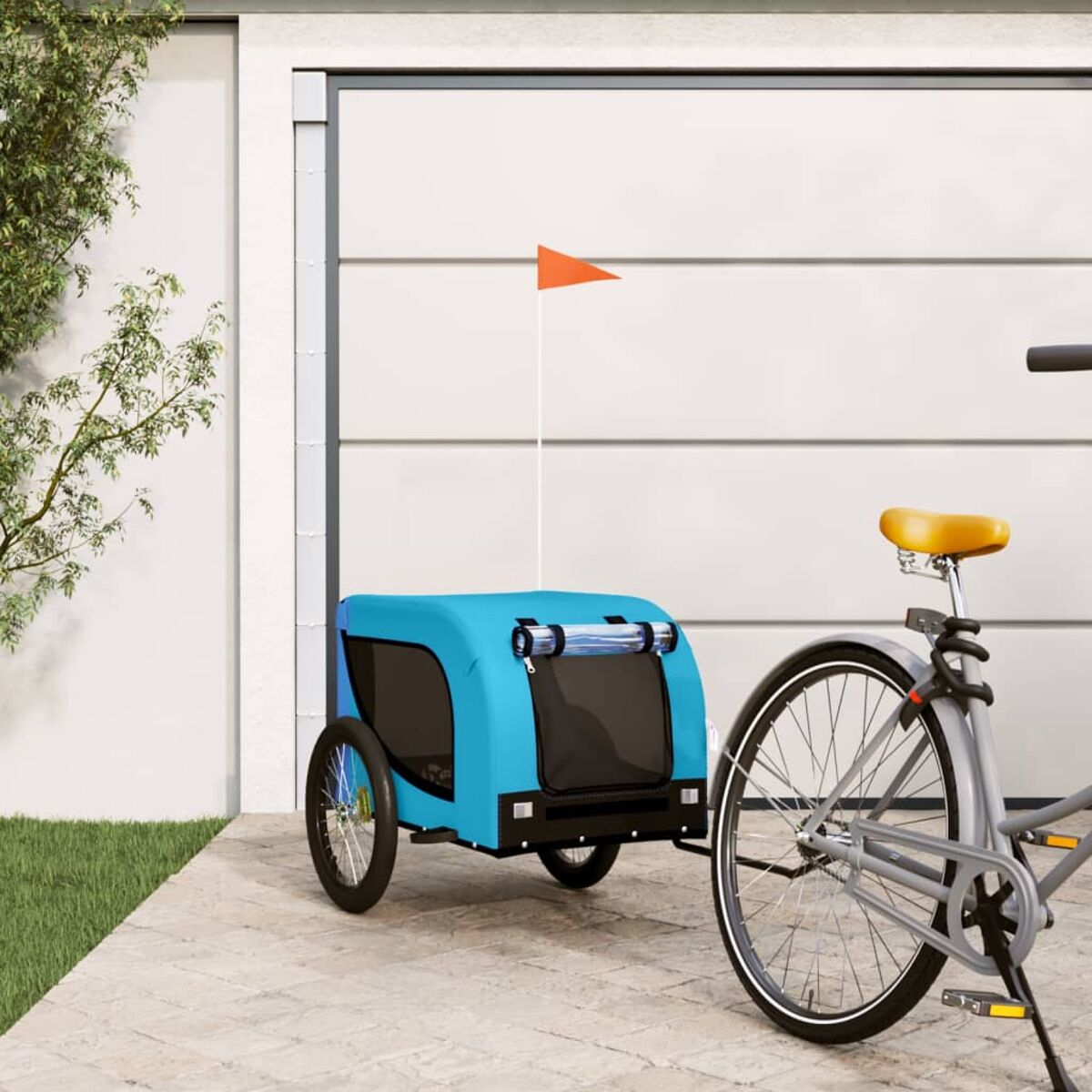 Blauer Haustieranhänger an grauem Fahrrad. Orangefarbene Fahne. Weisse Garagentür im Hintergrund.