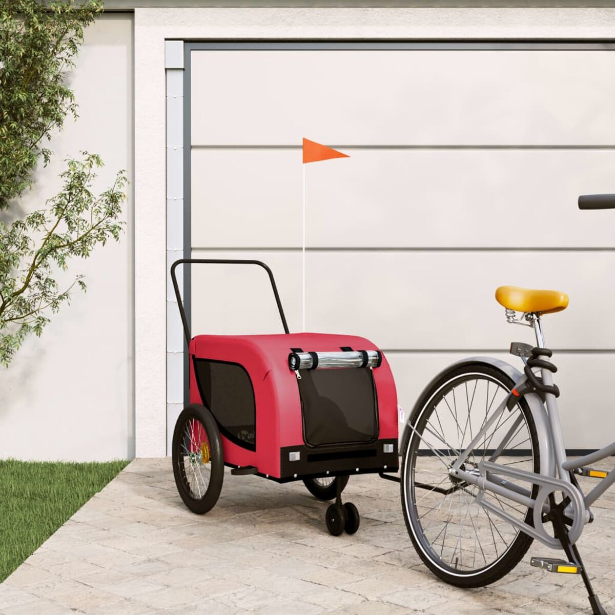 Roter Haustieranhänger an einem grauen Fahrrad. Orangefarbene Fahne. Auf Pflaster, weiße Tür.