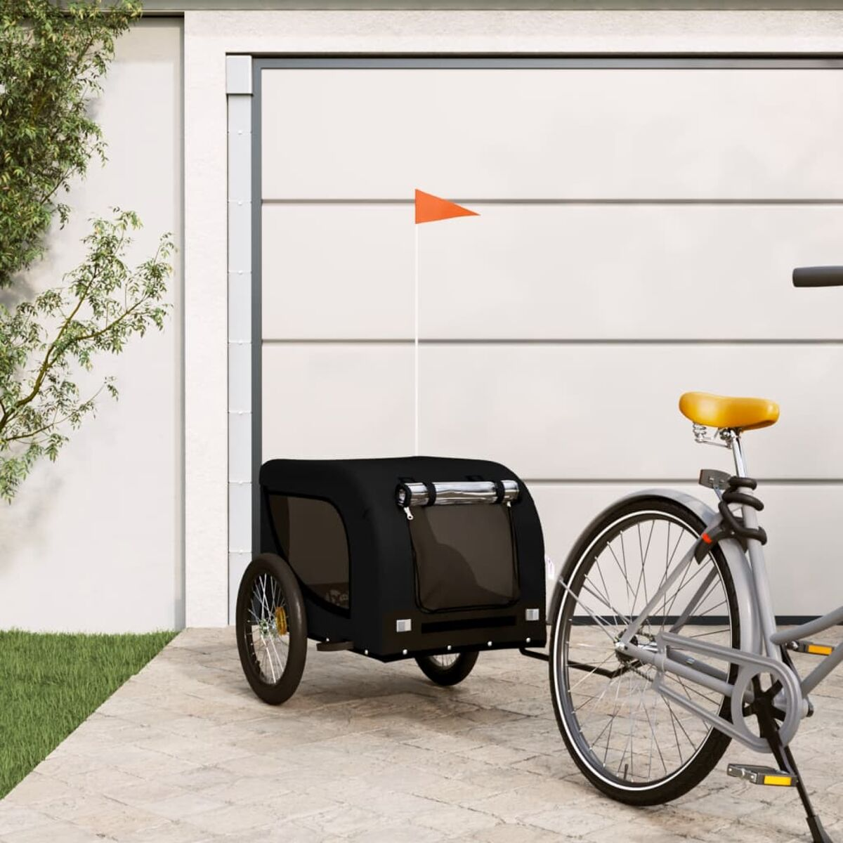 Schwarzer Fahrradanhänger für Haustiere an einem grauen Fahrrad. Oben eine orange Fahne.