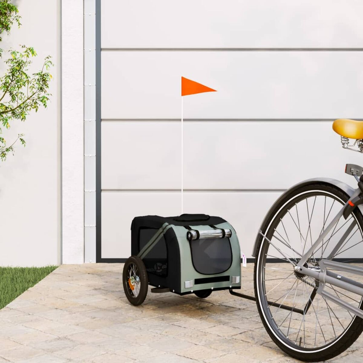 Fahrrad mit einem Haustieranhänger. Anhänger ist grau, mit einer orangefarbenen Fahne.