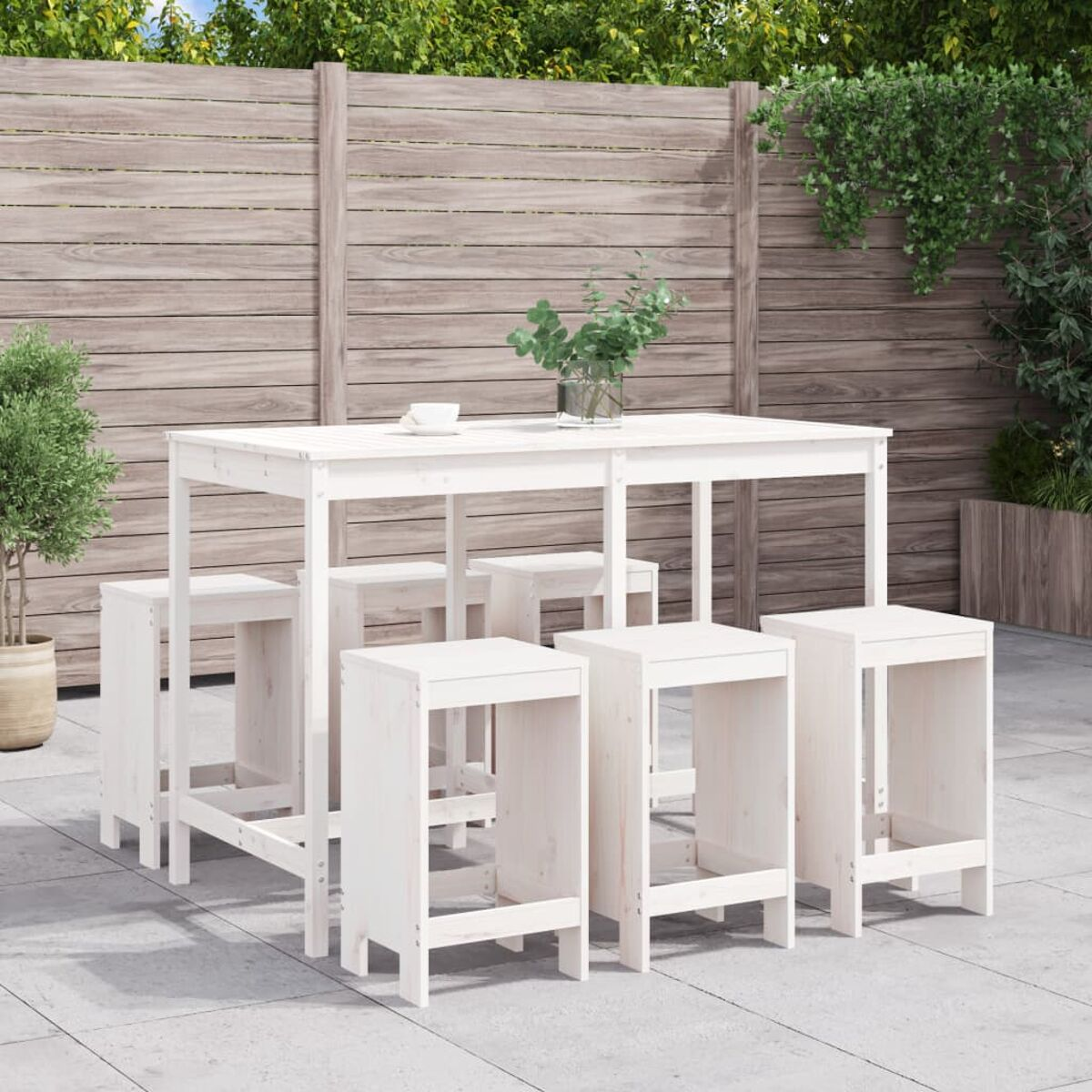 Weißes Ess-Set im Freien mit Tisch und Hockern auf der Terrasse, Holzzaun im Hintergrund.