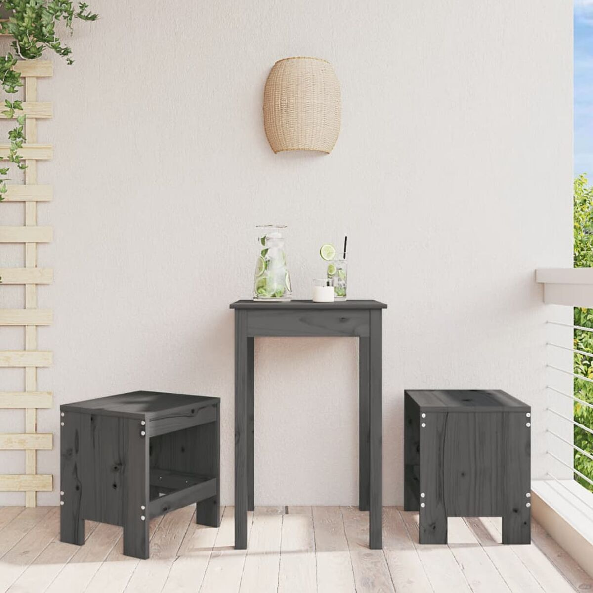 Grauer Tisch und Hocker auf einem Balkon mit Wasserkrug und Pflanze. Eine gewebte Lampe hängt oben.