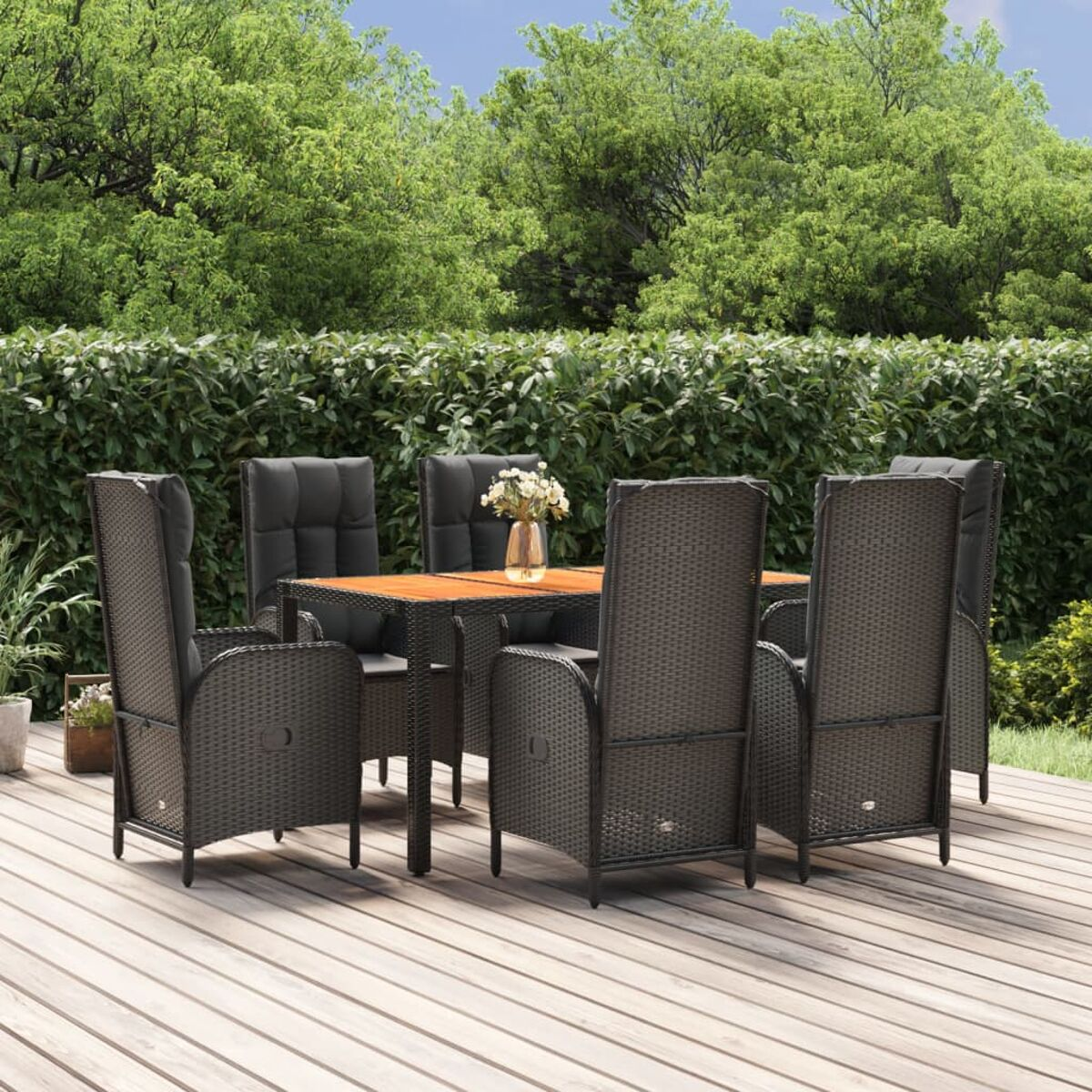 Geflochtenes Esszimmer-Set im Freien auf dem Deck. Tisch mit Vase und Stühlen.