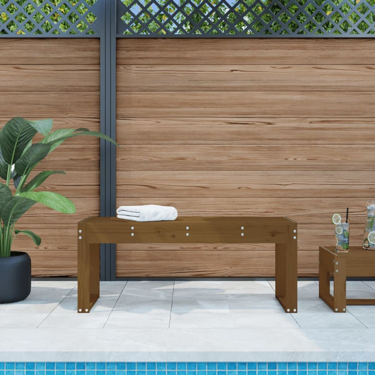 Holzbank und kleiner Tisch neben einem Pool, mit einem Holzzaun im Hintergrund.