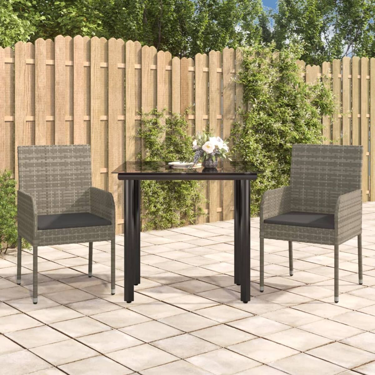 Terrassenset im Freien. Zwei Stühle und ein Tisch. Grüner Hintergrund und Fliesenboden.