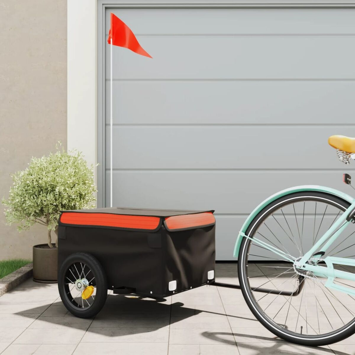 Ein Fahrrad mit Anhänger. Der Anhänger ist schwarz und rot, mit roter Fahne.