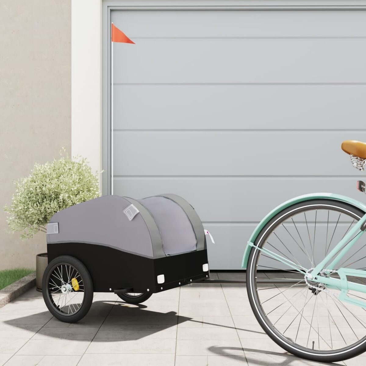 Ein Fahrrad mit Anhänger, geparkt vor einer Garage.