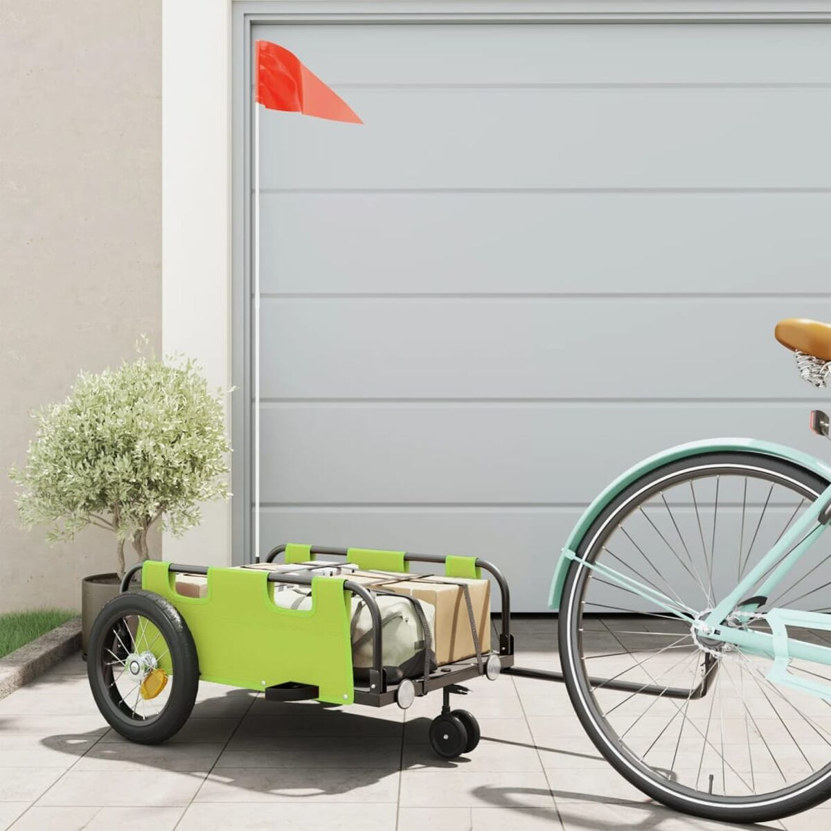 Ein Fahrrad zieht einen grünen Wagen mit Kisten. Eine rote Fahne ist am Wagen befestigt.