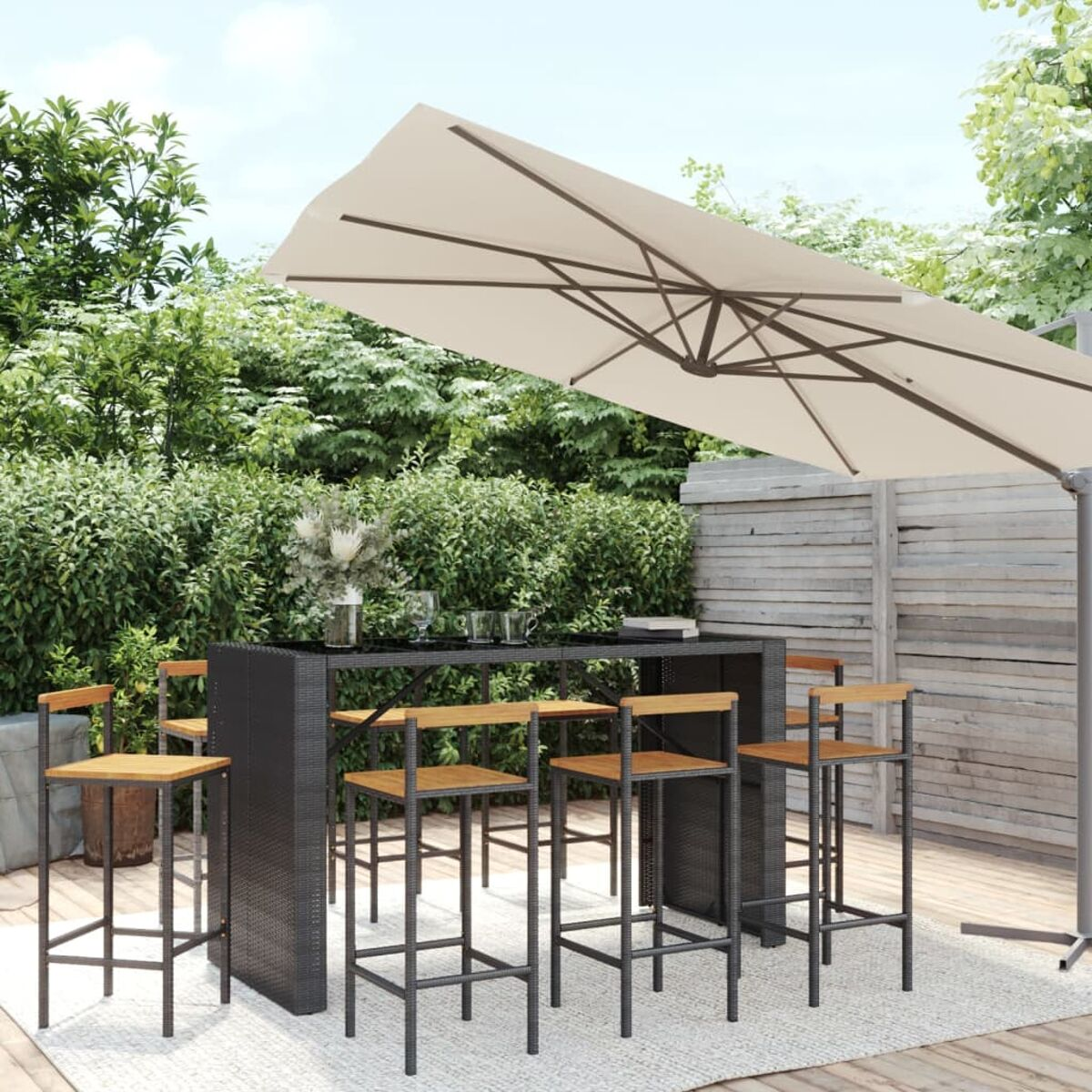Eine Outdoor-Bar-Set mit einem Sonnenschirm und Hockern.