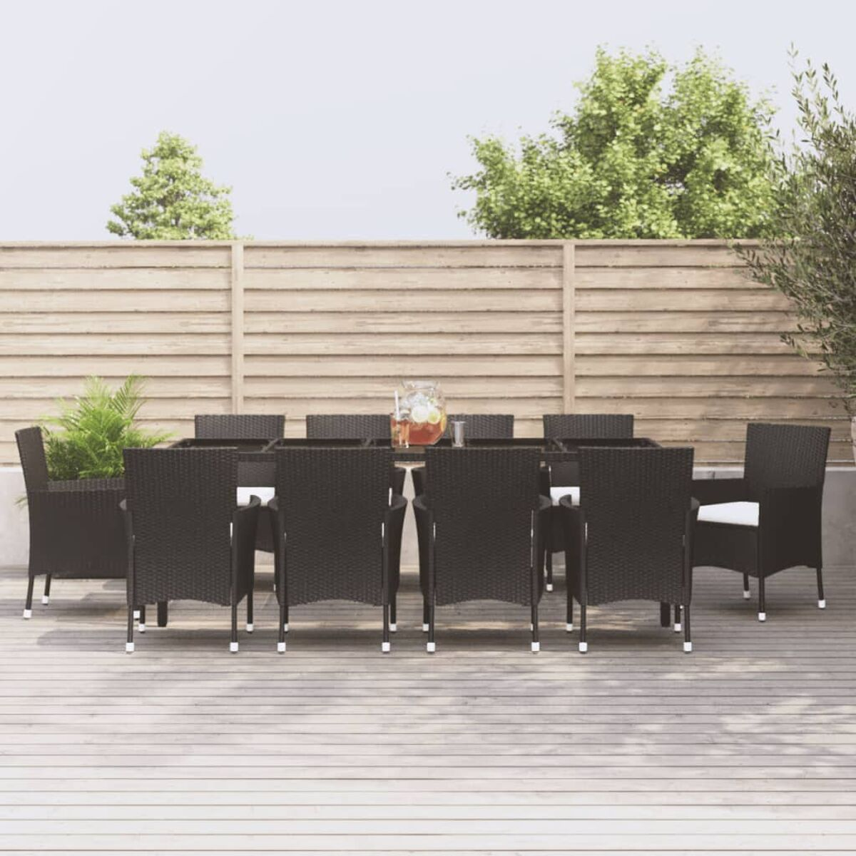 Essgruppe für den Außenbereich mit einem schwarzen Tisch und Stühlen. Die Szene befindet sich auf einer Holzterrasse.