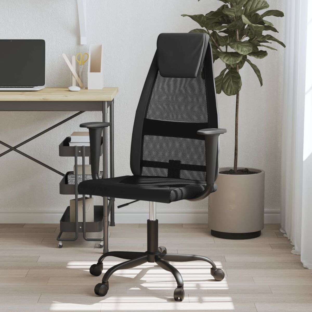 Schwarzer Bürostuhl mit Mesh-Gewebe, Schreibtisch und Pflanze im Hintergrund. Weiße Wand.